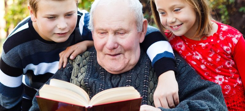 abuelo leyendo un cuento a sus nietos