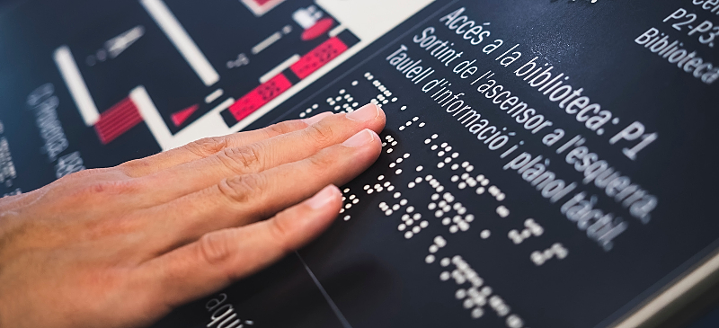 Lectura en braille en el acceso a una biblioteca