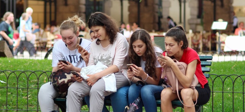adolescentes mirando el teléfono móvil
