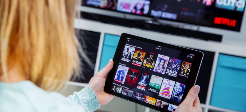 Chica mirando varias series de Netflix en una tablet.