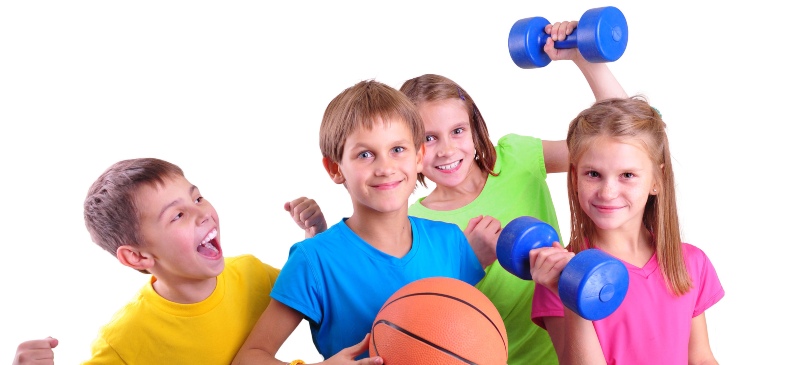 Niños sonriendo con pelota de baloncesto y mancuernas