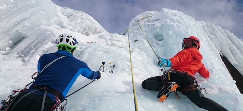 escaladores sobre una cascada de hielo practicando deporte