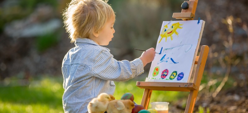 Niño pintando un cuadro al aire libre