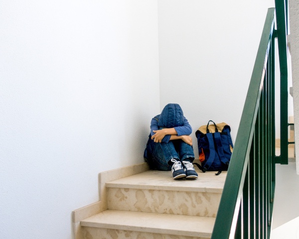 Niño en las escaleras del colegio llorando