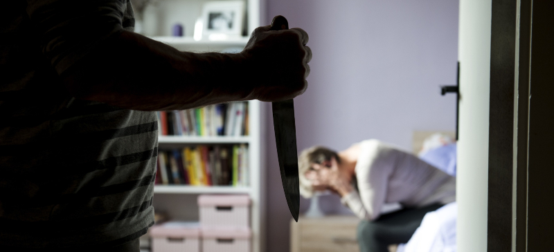 Hombre con un cuchillo en la mano amenazando a una mujer