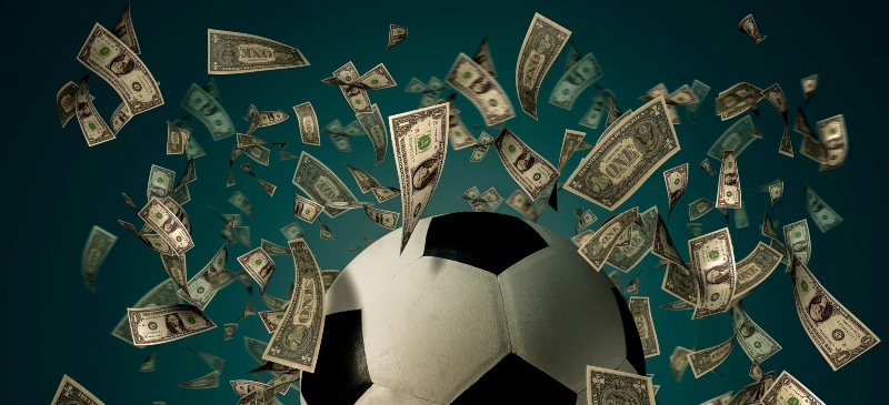 Balón de fútbol rodeado de billetes