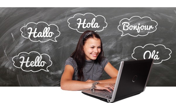 chica frente a un ordenador y con varios hola en distintos idiomas