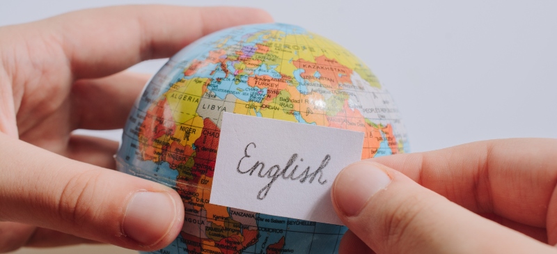 Bola del mundo con una pegatina de inglés, metáfora del uso del inglés en el mundo.