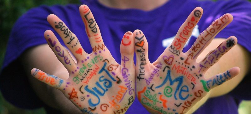 manos con palabras de emociones pintadas en las palmas