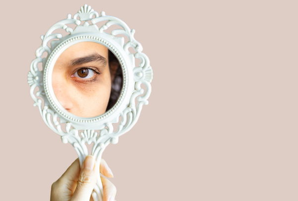 Ojo de mujer ojeroso reflejado en un espejo