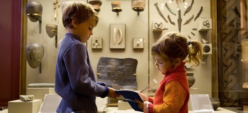 Los niños en un museo con sus cuadernos de notas para aprender.