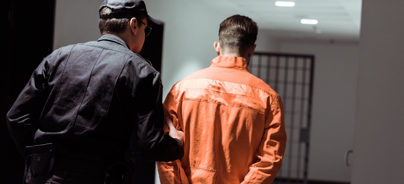 Oficial de prisiones guiando a un preso hacia su celda