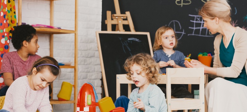 Maestra y estudiantes en una clase de educación infantil