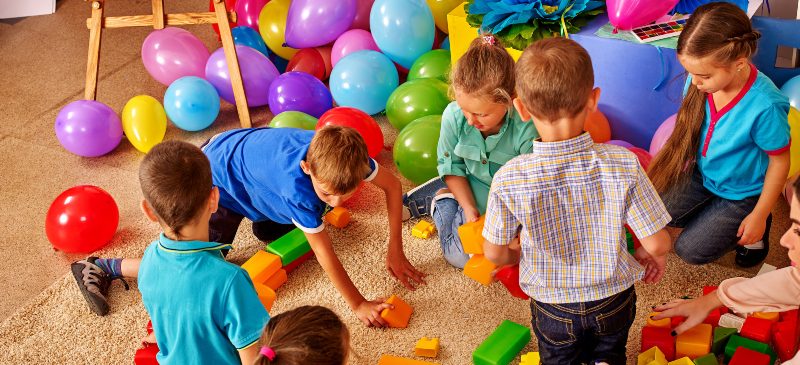 Profesora en una clase de infantil con los alumnos en la zona de juegos