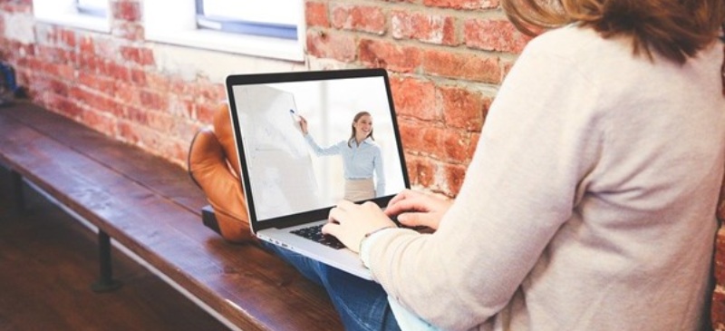 Mujer ante un ordenador manteniendo una videoconferencia con otra mujer.