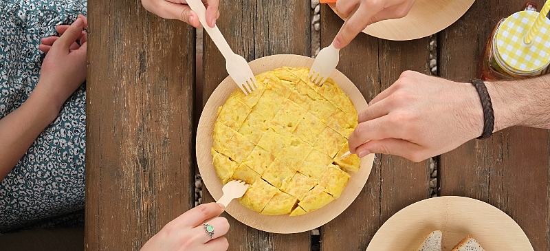 Grupo de personas comparte una tortilla de patata.
