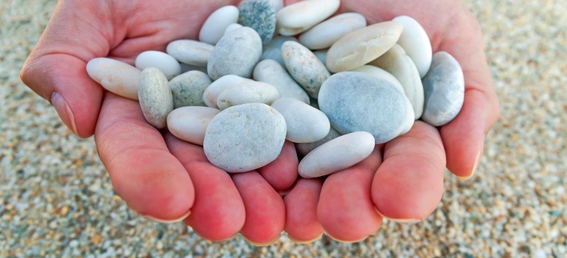 Piedras entre las dos manos en una playa