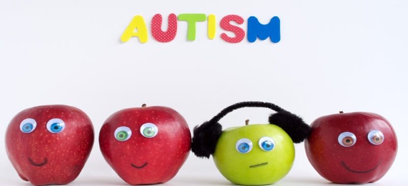 Autismo, metáfora de manzanas. Todas rojas y una verde con auriculares (ejemplo del aislamiento del autista).