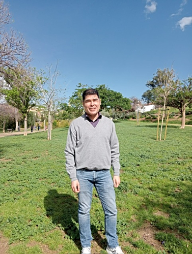 Carlos en un parque con hierba verde.