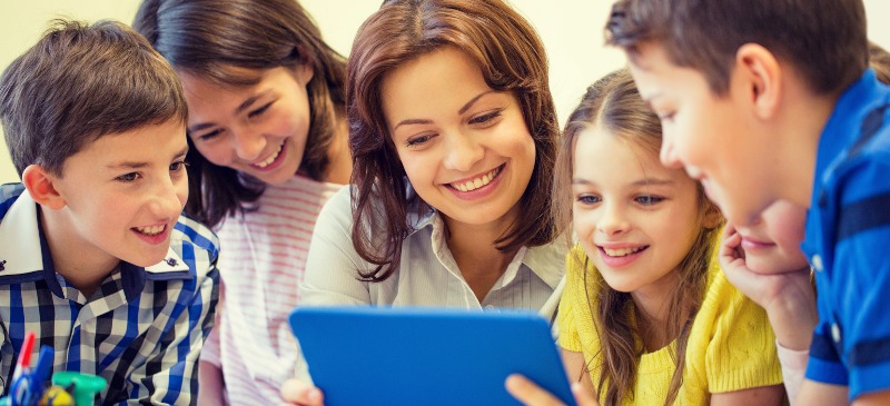 Profesora con niños mirando una tablet