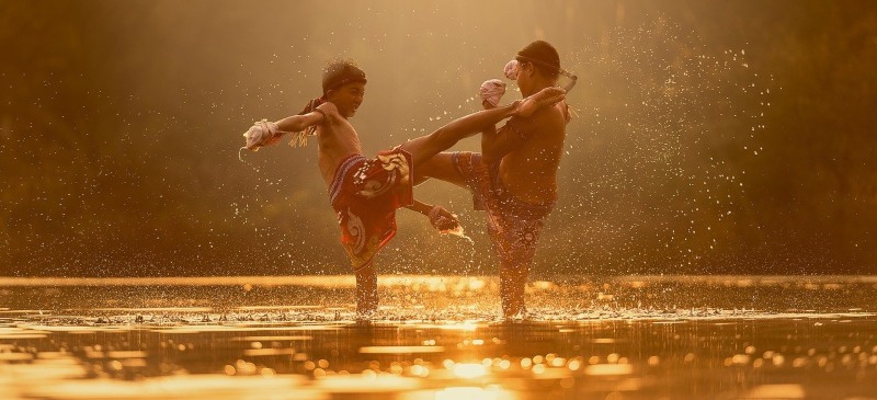 Dos jóvenes practicando kickboxing en el agua