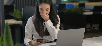 Mujer asustada al leer un mensaje en redes sociales a través de su teléfono móvil