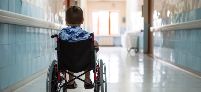 Niño en silla de ruedas en el pasillo de un hospital