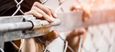 Prisión permanente revisable, manos en una reja.