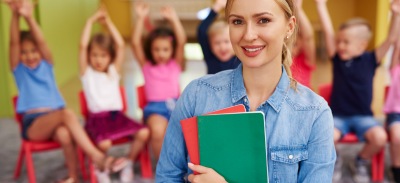 Profesora de primaria con niños detrás en una clase