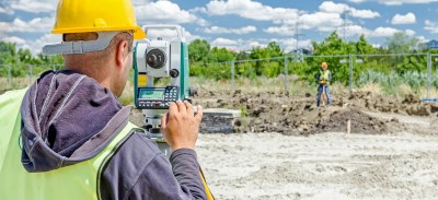 El topógrafo mide los lindes oficiales entre propiedades.